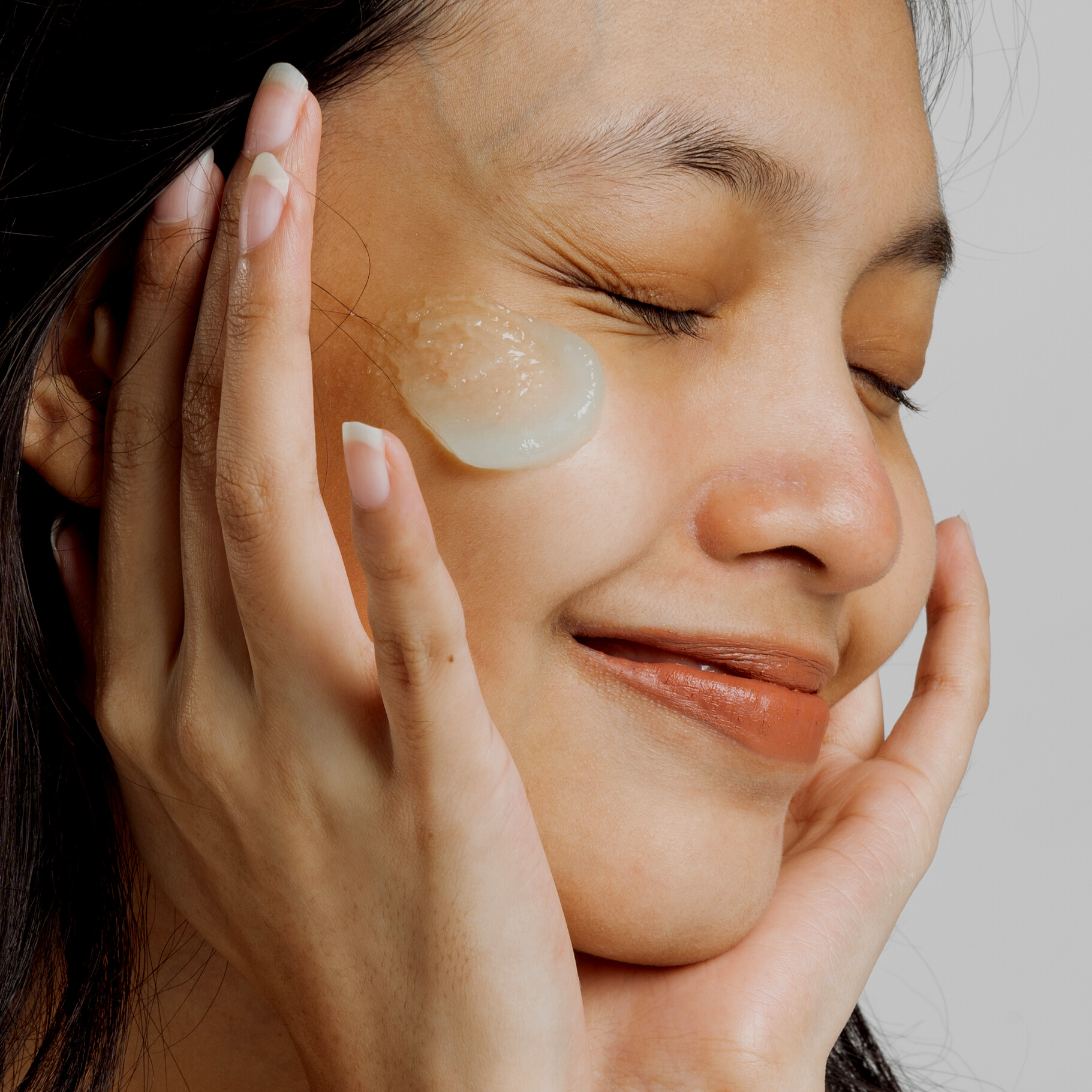 Closeup Portrait of Smiling Woman with Moisturizer