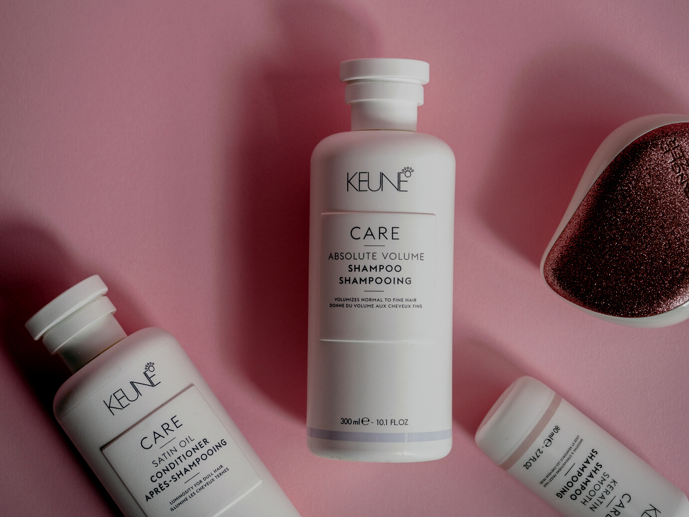 A Close-Up Shot of Hair Care Products on a Pink Surface